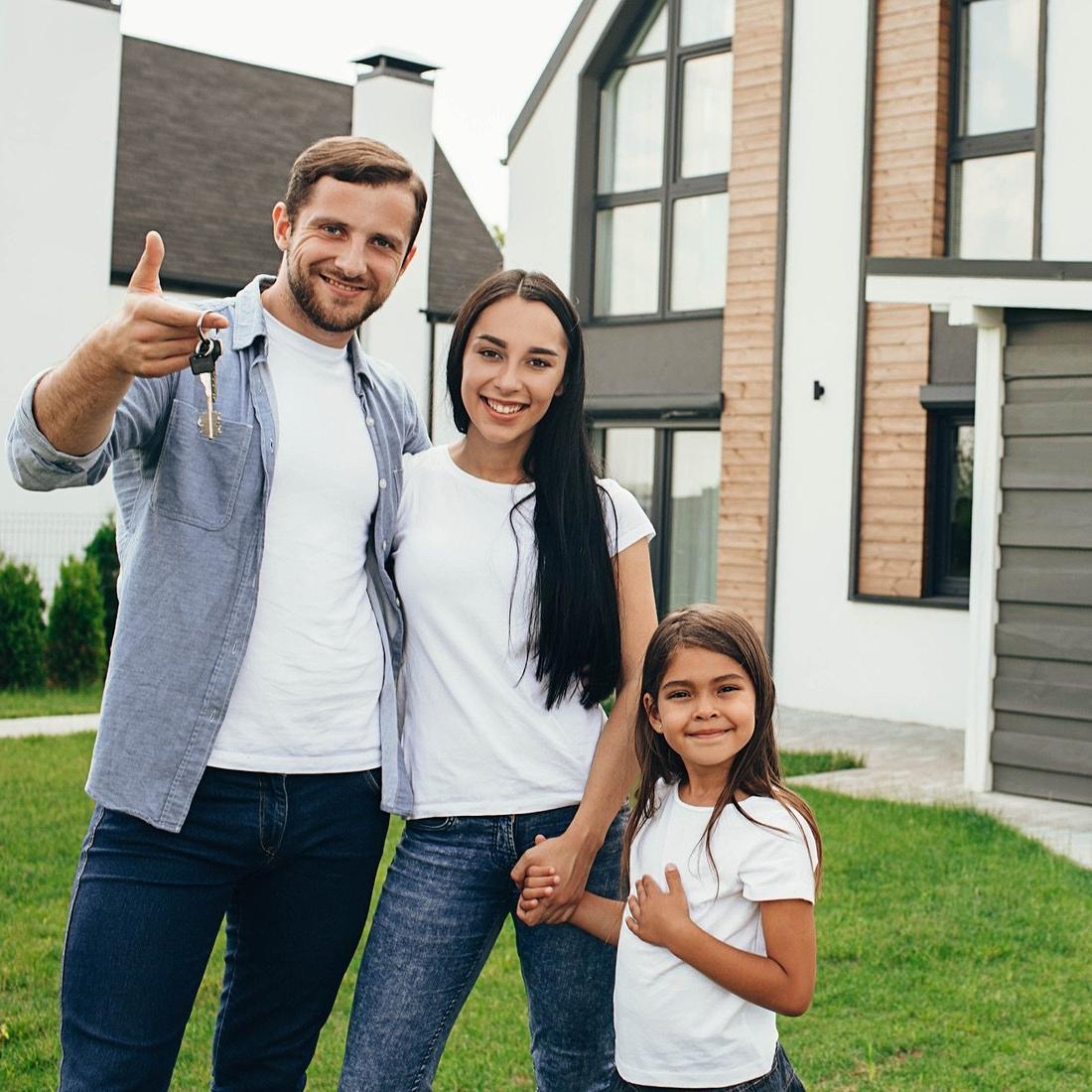 family with keys outside new home